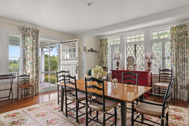 dining space with a wealth of natural light, french doors, and hardwood / wood-style flooring