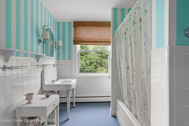 bathroom with shower / bath combination with curtain, a baseboard radiator, and tile walls