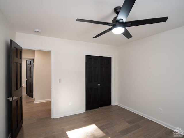 unfurnished bedroom with wood finished floors, baseboards, and a closet