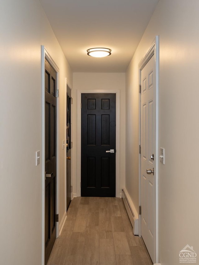 doorway featuring a baseboard radiator and baseboards