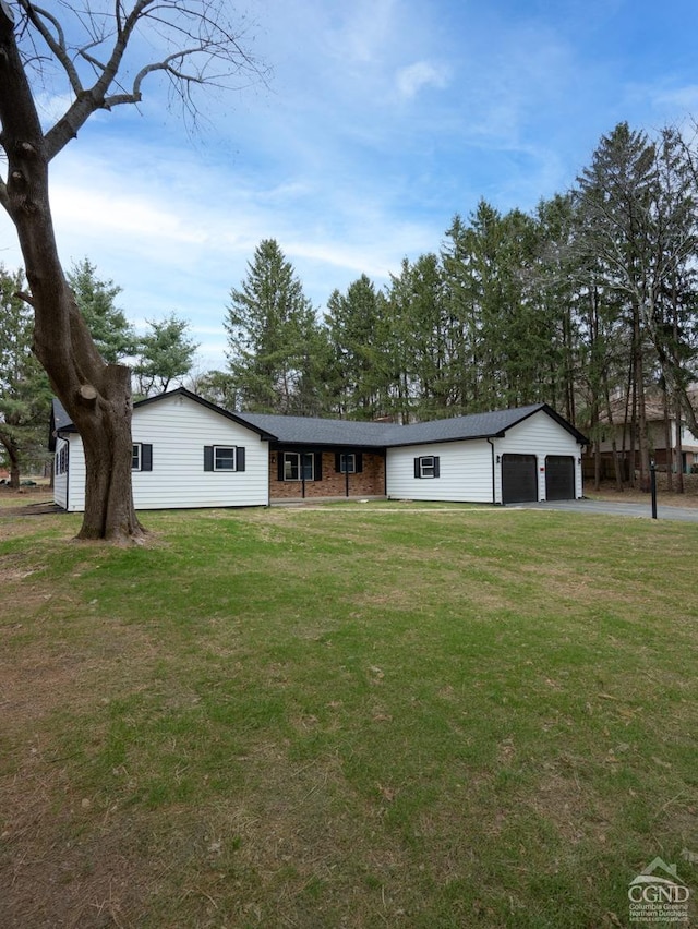 ranch-style house featuring a front lawn and a garage