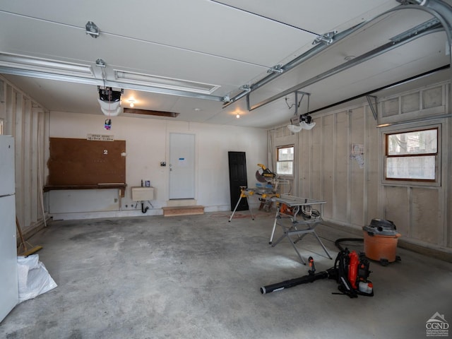 garage featuring a garage door opener and freestanding refrigerator