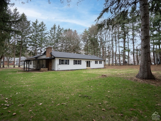 view of side of property featuring a chimney and a lawn