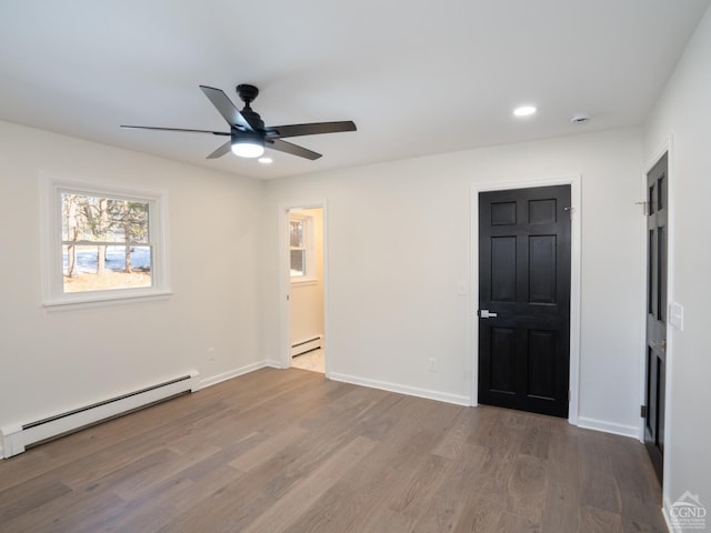 unfurnished room featuring baseboard heating, ceiling fan, wood finished floors, recessed lighting, and baseboards