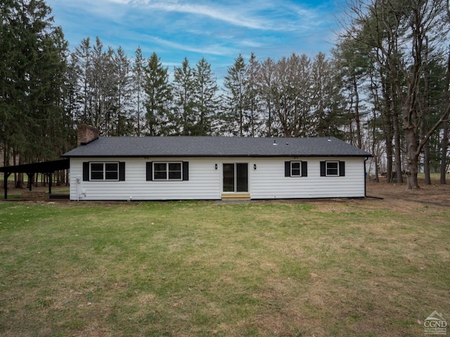 rear view of house with a chimney and a yard