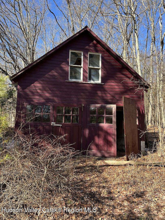 view of side of home featuring a garage and an outbuilding