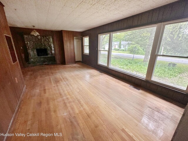 1918 County Route 8, Elizaville, NY 12523 - unfurnished living room featuring light wood-style floors, wooden walls, and a fireplace