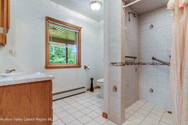 bathroom with a shower with curtain, a baseboard heating unit, tile patterned floors, toilet, and vanity