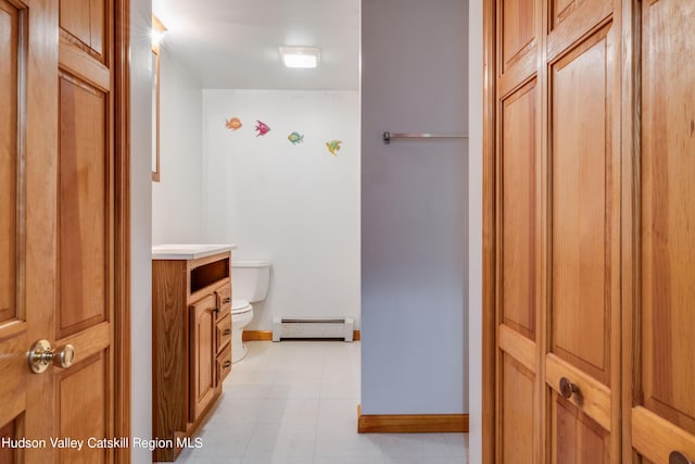 bathroom featuring baseboard heating, vanity, and toilet