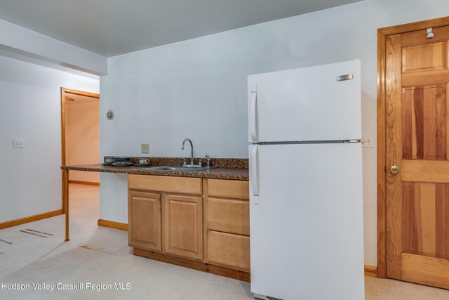 kitchen featuring white refrigerator and sink