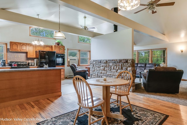 dining room featuring light wood-type flooring, high vaulted ceiling, and plenty of natural light