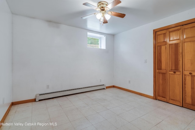 tiled empty room featuring ceiling fan and a baseboard heating unit