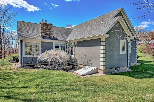 52 Hadley Dr, New Baltimore, NY 12087 - view of front of home with a front yard, roof with shingles, a chimney, and stucco siding