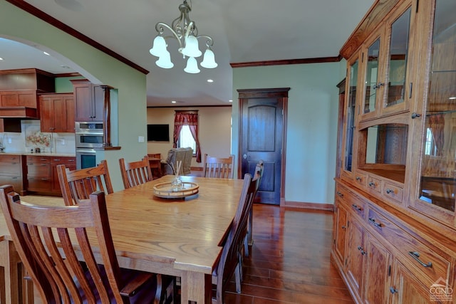 52 Hadley Dr, New Baltimore, NY 12087 - dining room featuring crown molding, dark wood-type flooring, arched walkways, a chandelier, and baseboards