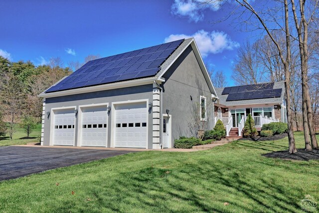 52 Hadley Dr, New Baltimore, NY 12087 - view of front of house with solar panels, stucco siding, a front yard, a garage, and covered porch