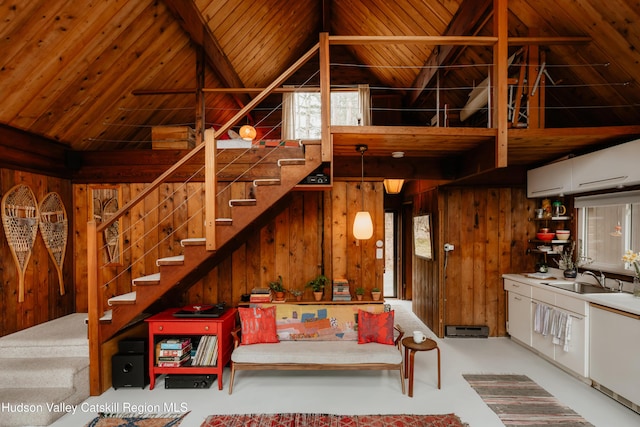 living room featuring wood ceiling, wood walls, and stairs
