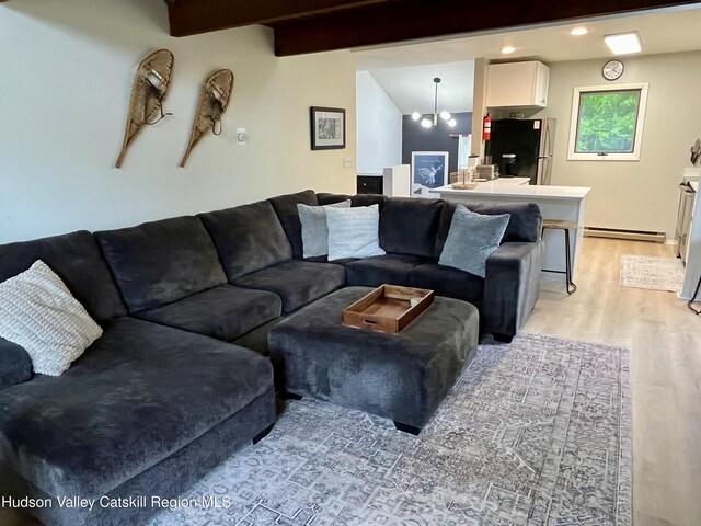 72 Hunter Dr Unit L-1, Hunter, NY 12442 - living area featuring light wood finished floors, a baseboard radiator, a chandelier, beamed ceiling, and recessed lighting