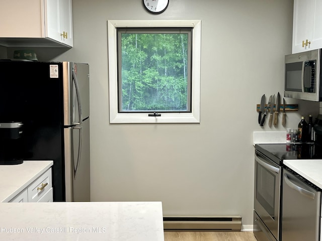 72 Hunter Dr Unit L-1, Hunter, NY 12442 - kitchen featuring appliances with stainless steel finishes, a baseboard heating unit, white cabinets, light countertops, and wood finished floors