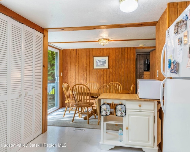 315 Begley Rd, Windham, NY 12496 - dining area with wood walls, beam ceiling, and tile patterned floors