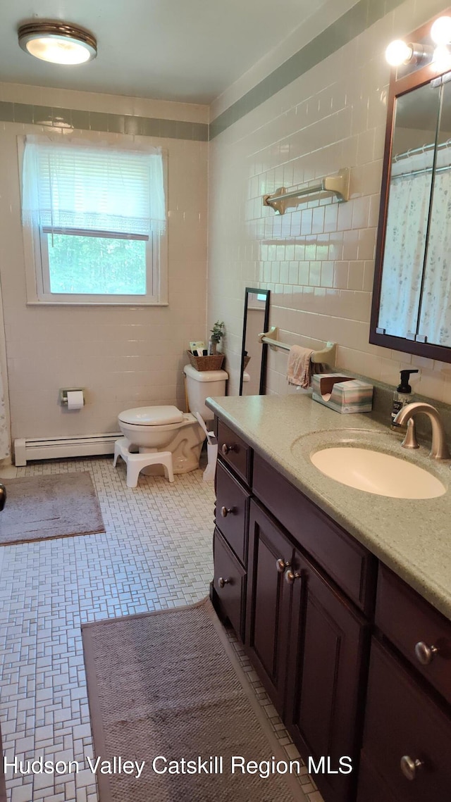 56 Church St, Plattekill, NY 12589 - bathroom featuring baseboard heating, vanity, toilet, and tile walls