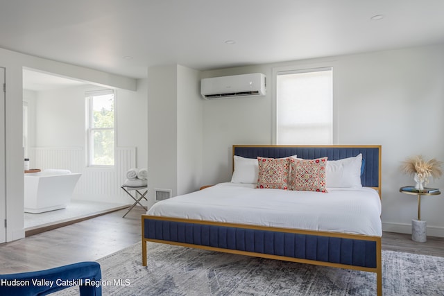 bedroom featuring hardwood / wood-style floors and an AC wall unit