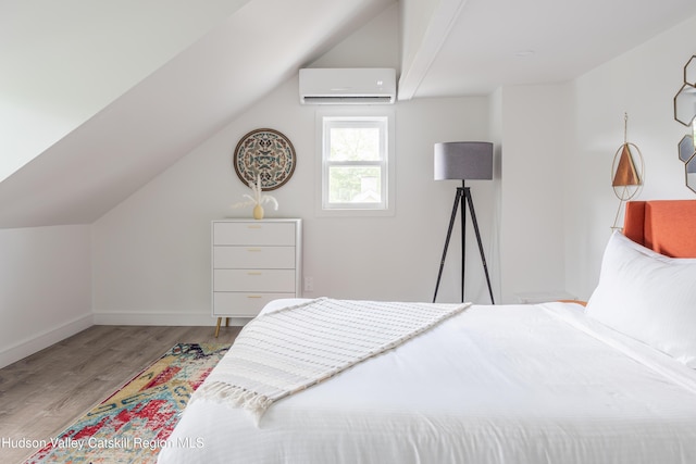 bedroom featuring lofted ceiling, light hardwood / wood-style flooring, and a wall mounted air conditioner