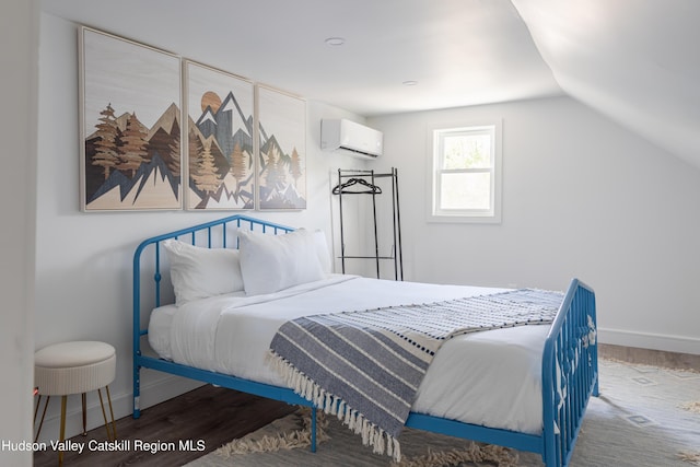 bedroom with a wall mounted air conditioner, hardwood / wood-style floors, and vaulted ceiling