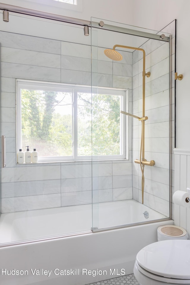 bathroom with combined bath / shower with glass door, tile patterned floors, toilet, and plenty of natural light