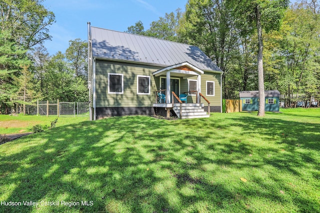 view of front of house with a front yard and a shed