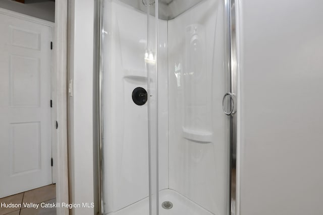 bathroom with tile patterned floors and an enclosed shower