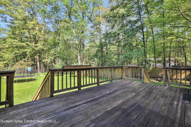 deck with a lawn and a trampoline