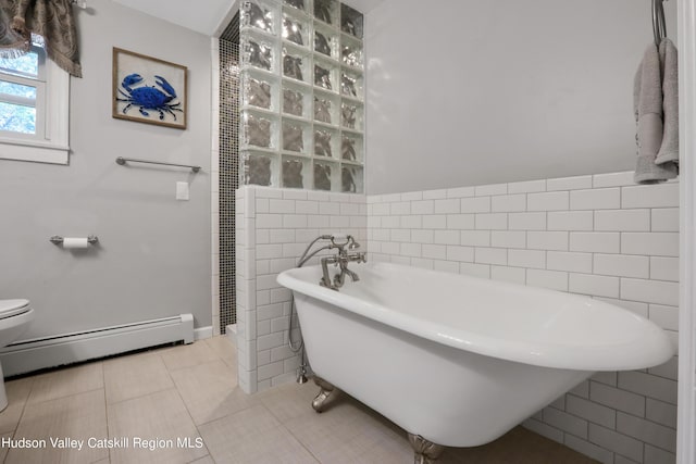 bathroom with tile patterned floors, a bathtub, a baseboard radiator, tile walls, and toilet