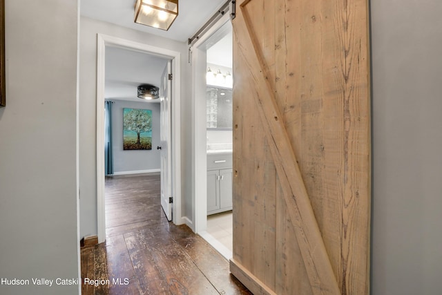 corridor featuring wood-type flooring and a barn door