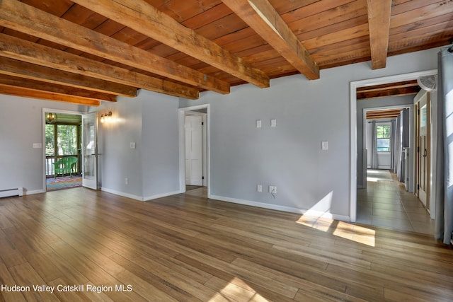 empty room featuring hardwood / wood-style floors, wood ceiling, beamed ceiling, and a baseboard heating unit