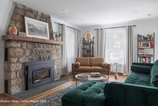 living room with wood finished floors and a large fireplace