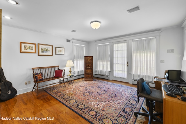 office with baseboards, ornamental molding, wood finished floors, and visible vents