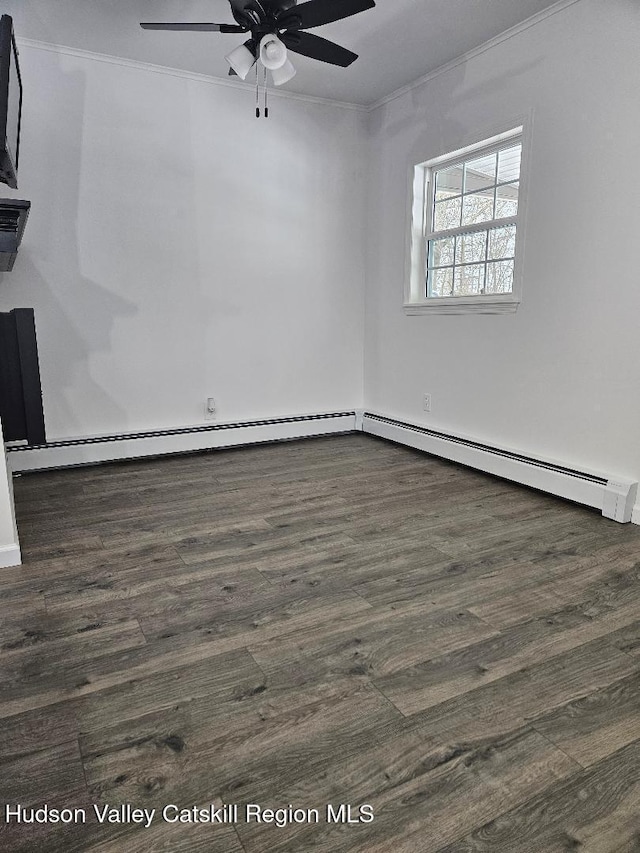 empty room featuring a ceiling fan, baseboard heating, wood finished floors, and crown molding