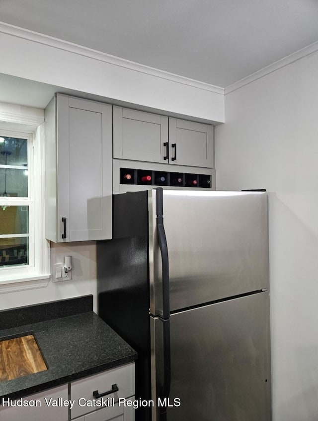 kitchen with dark countertops, crown molding, freestanding refrigerator, and gray cabinetry