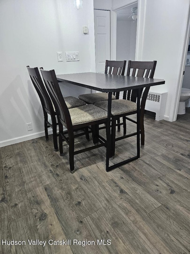 dining area with dark wood-type flooring and baseboards