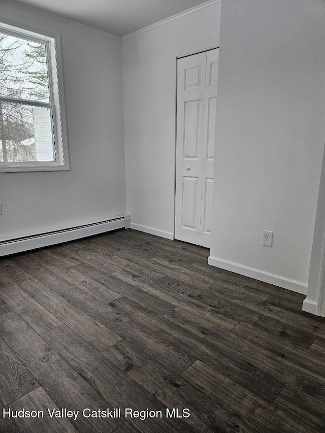 unfurnished room featuring a baseboard radiator, baseboards, dark wood-type flooring, and crown molding