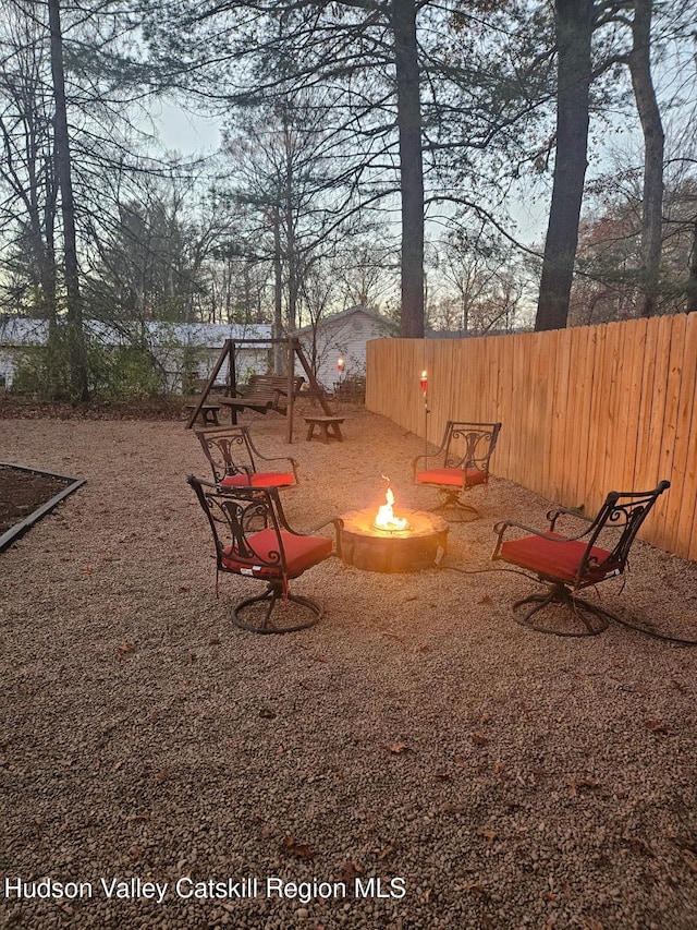 view of playground featuring fence and a fire pit