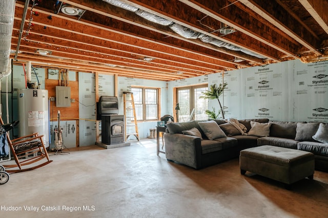 living room featuring concrete floors, electric panel, and water heater