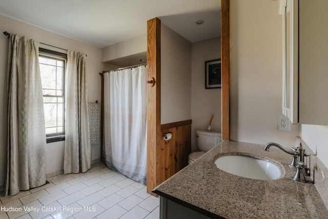 bathroom featuring tile patterned flooring, vanity, and toilet