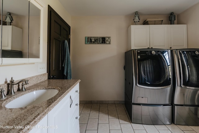 clothes washing area featuring washer and dryer, light tile patterned floors, cabinets, and sink