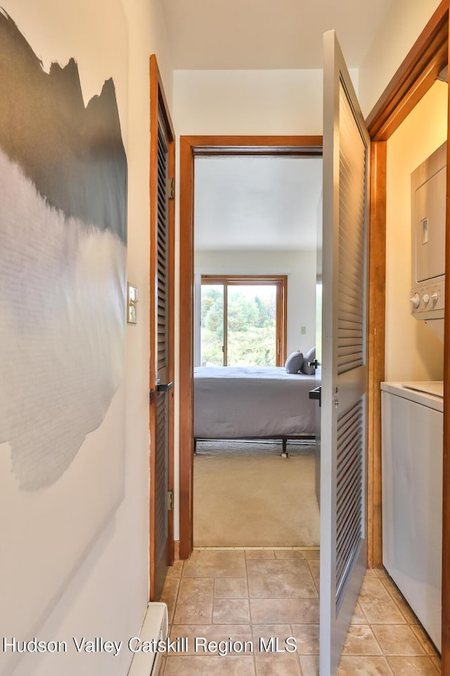 28 Loo Bridge Ln Unit 22A, Windham, NY 12496 - corridor with stacked washer / dryer, light carpet, and light tile patterned flooring