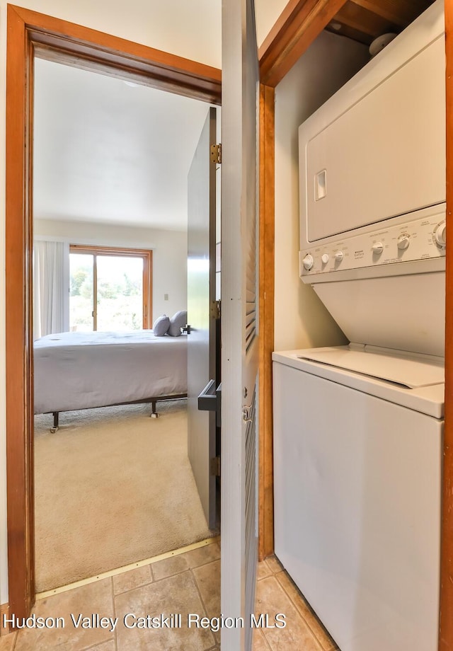 28 Loo Bridge Ln Unit 22A, Windham, NY 12496 - laundry room with stacked washer / drying machine, light carpet, and light tile patterned floors