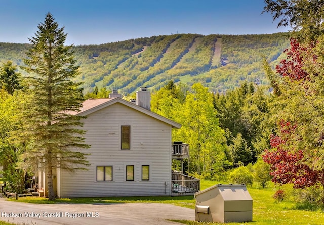 28 Loo Bridge Ln Unit 22A, Windham, NY 12496 - view of home's exterior featuring a chimney, a mountain view, a view of trees, and a balcony