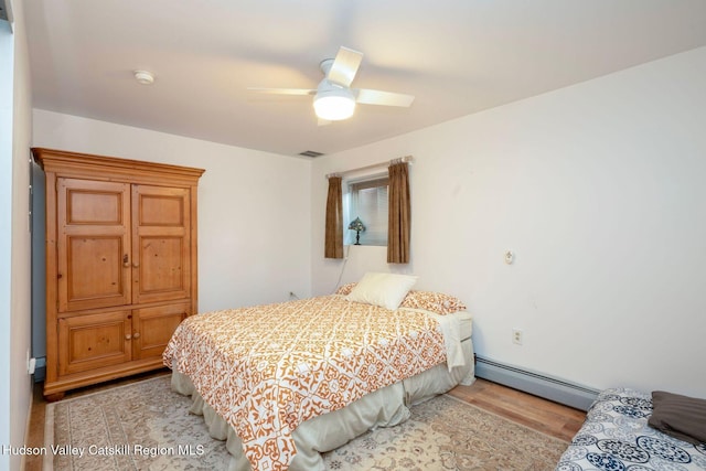 59 Mountain Dr, Hunter, NY 12442 - bedroom with a baseboard heating unit, light wood finished floors, and a ceiling fan