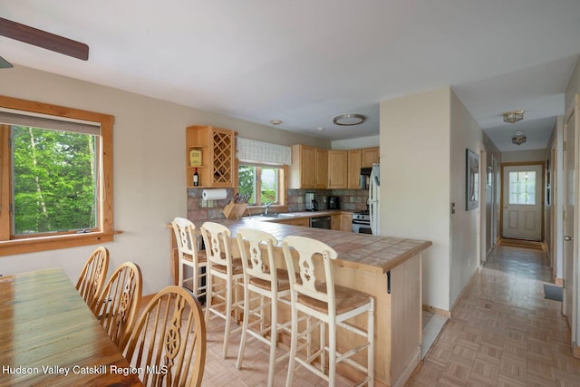 59 Mountain Dr, Hunter, NY 12442 - kitchen featuring a peninsula, a kitchen bar, tile counters, tasteful backsplash, and light brown cabinetry