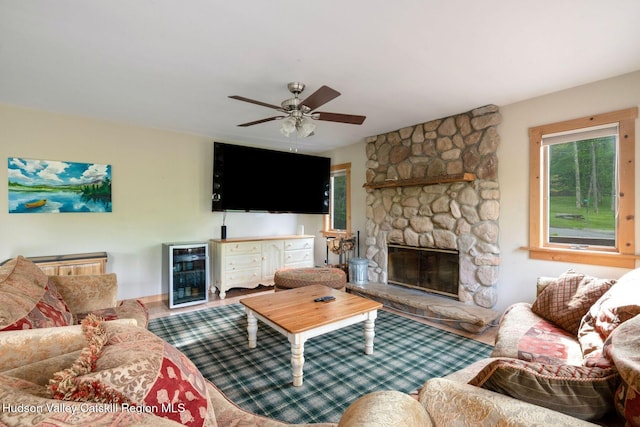 59 Mountain Dr, Hunter, NY 12442 - living room featuring wine cooler, a ceiling fan, a fireplace, and wood finished floors